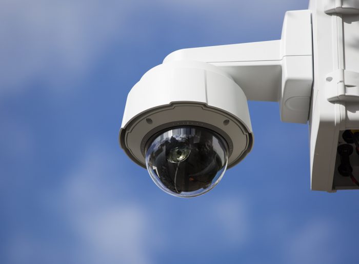 Surveillance camera against blue sky
